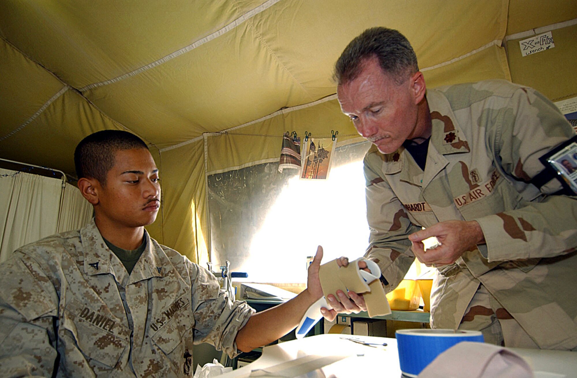 BALAD AIR BASE, Iraq -- Maj. Peter Reinhardt fits a splint for Marine Lance Cpl. Kai Daniel, who was visiting the Air Force theater hospital here from Tikrit.  Major Reinhardt is an occupational therapist with the 332nd Expeditionary Medical Group here.  (U.S. Air Force photo by Tech. Sgt. Robert Jensen)