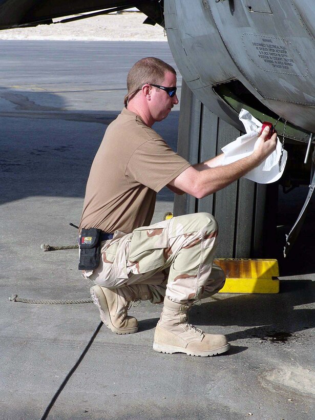 SOUTHWEST ASIA -- Tech. Sgt. Scott Wagner checks a C-130 Hercules for oil leaks Oct. 18 before the aircraft flies on a mission into Iraq.  He is assigned to the 746th Expeditionary Maintenance Squadron at a forward-deployed location and is from the Wyoming Air National Guard.  (U.S. Air Force photo by Senior Airman Nicole Spence)