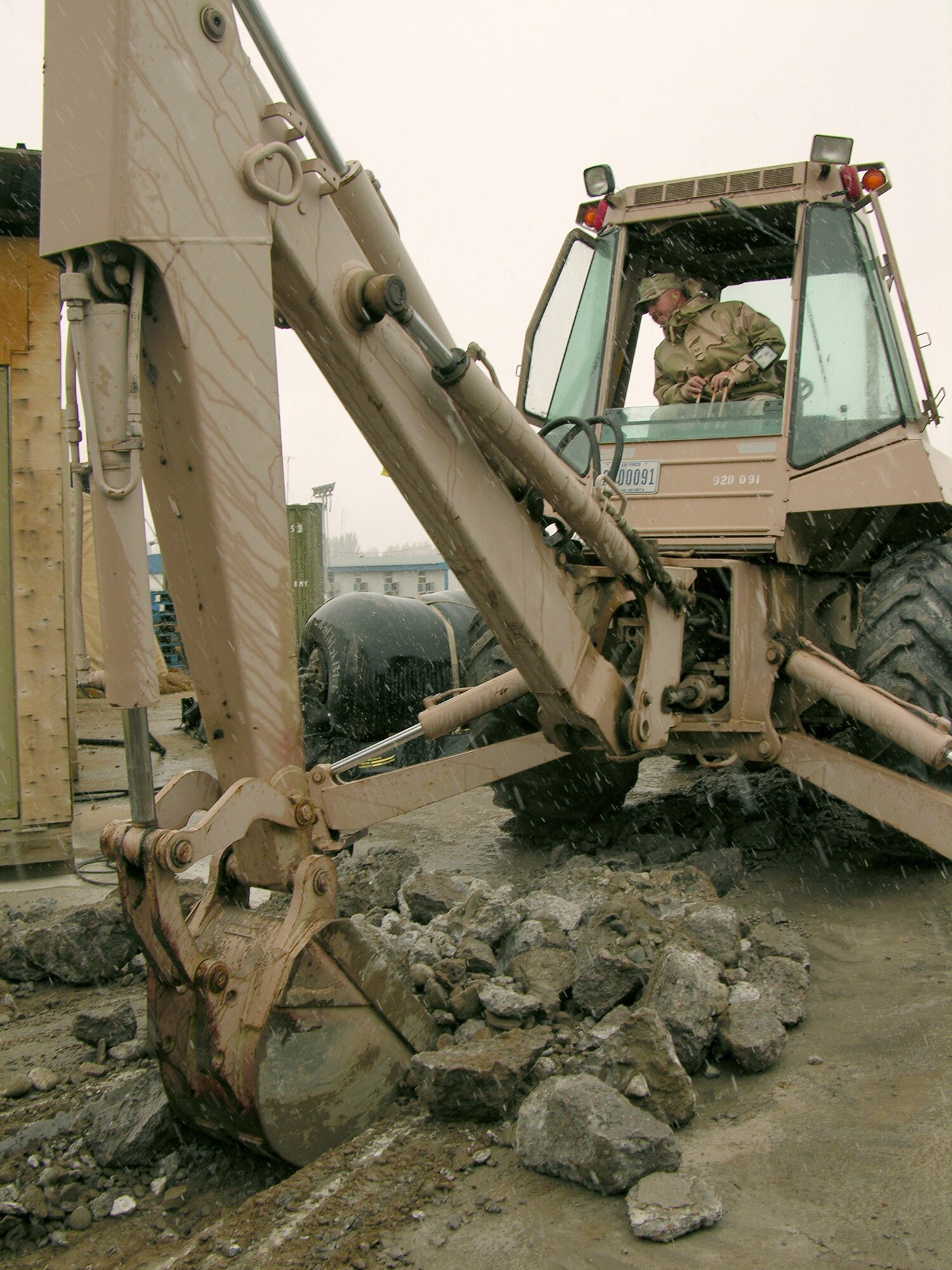 MANAS AIR BASE, Kyrgyzstan -- Tech. Sgt. Robert Wyatt scoops up rubble to create a hole to run electrical cable.  He is assigned to the 376th Expeditionary Civil Engineer Squadron here and is deployed from Robins Air Force Base, Ga.  (Courtesy photo)
