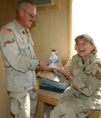 KANDAHAR AIRFIELD, Afghanistan -- Chief Warrant Officer Tim Gaby surprises his sister, Tech. Sgt. Rebecca Jo Allen, with a quart of maple syrup from the family farm back in northeastern Indiana.  Sergeant Allen is a passenger terminal nightshift manager assigned to the 455th Expeditionary Logistics Readiness Squadron at Bagram Air Base, Afghanistan.  Chief Gaby is an ammunition supply point accountable officer assigned to the 221st Ordnance Co.  The siblings saw each other for the first time in three years while deployed in Afghanistan.  (U.S. Air Force photo by Staff Sgt. Jennifer Lindsey)
