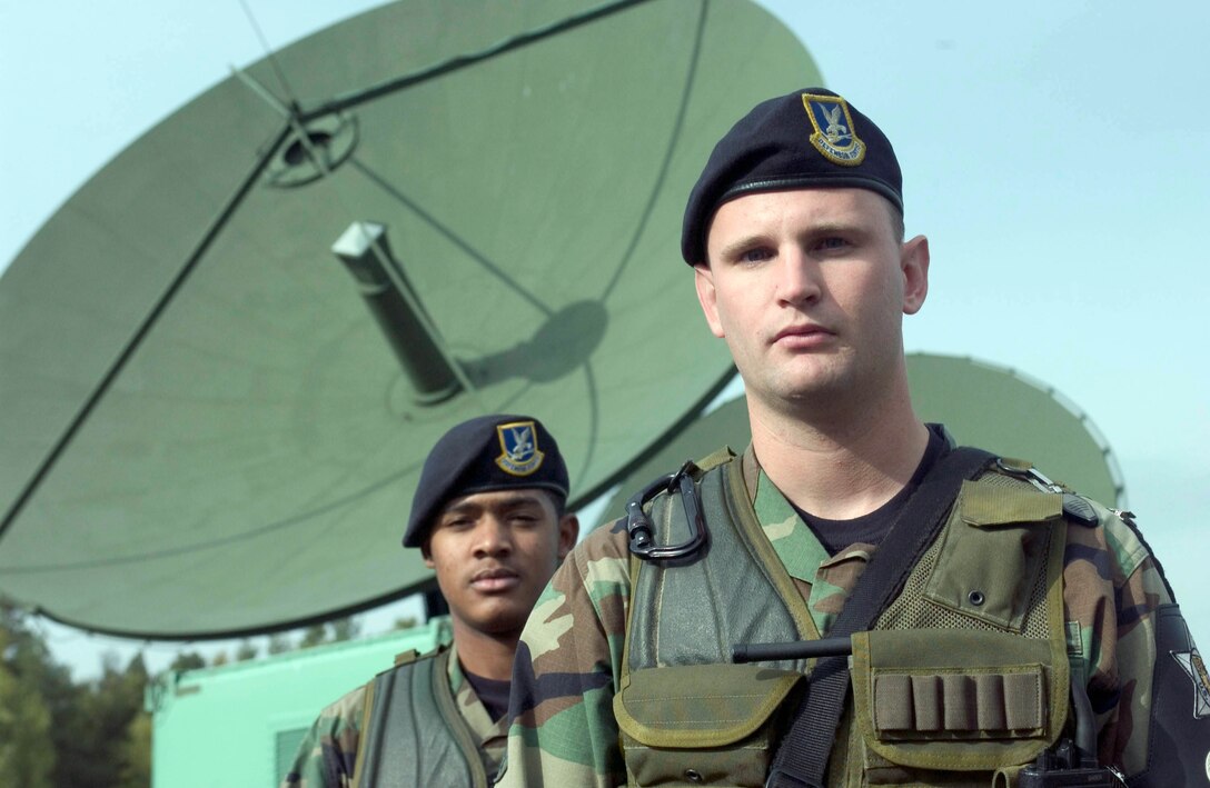 KAPAUN AIR STATION, Germany -- Law enforcement specialists Airmen 1st Class Adrian Gillette and Timothy Zink are responsible for the security here at Detachment 1 of the 460th Space Communication Squadron.  They are assigned to the 569th U.S. Forces Police Squadron at nearby Vogelweh Air Base.  The Airmen walk the perimeter of the satellite relay station, and they check the condition of the fence, debris gathered against it and suspicious activity.  The detachment provides critical defense communications data to other units around the world.  (U.S. Air Force photo by Master Sgt. John E. Lasky)