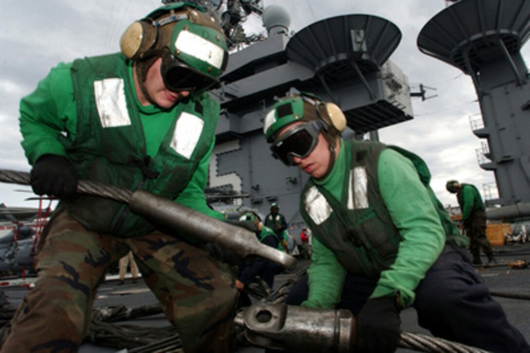 Airmen Brandon Davis (left) and Zack St. Germaine connect a cross-deck pendent arresting wire to its purchase cable as other sailors rig the emergency-landing barricade during a drill on the flight deck of the aircraft carrier USS Harry S. Truman (CVN 75) on Oct. 18, 2004. In an emergency situation the barricade would be stretched across the carrier's flight deck to catch a malfunctioning aircraft and ensure the safety of the aircrew and the carrier's flight deck crew. The Truman Carrier Strike Group is conducting carrier qualifications in the eastern Atlantic Ocean. 