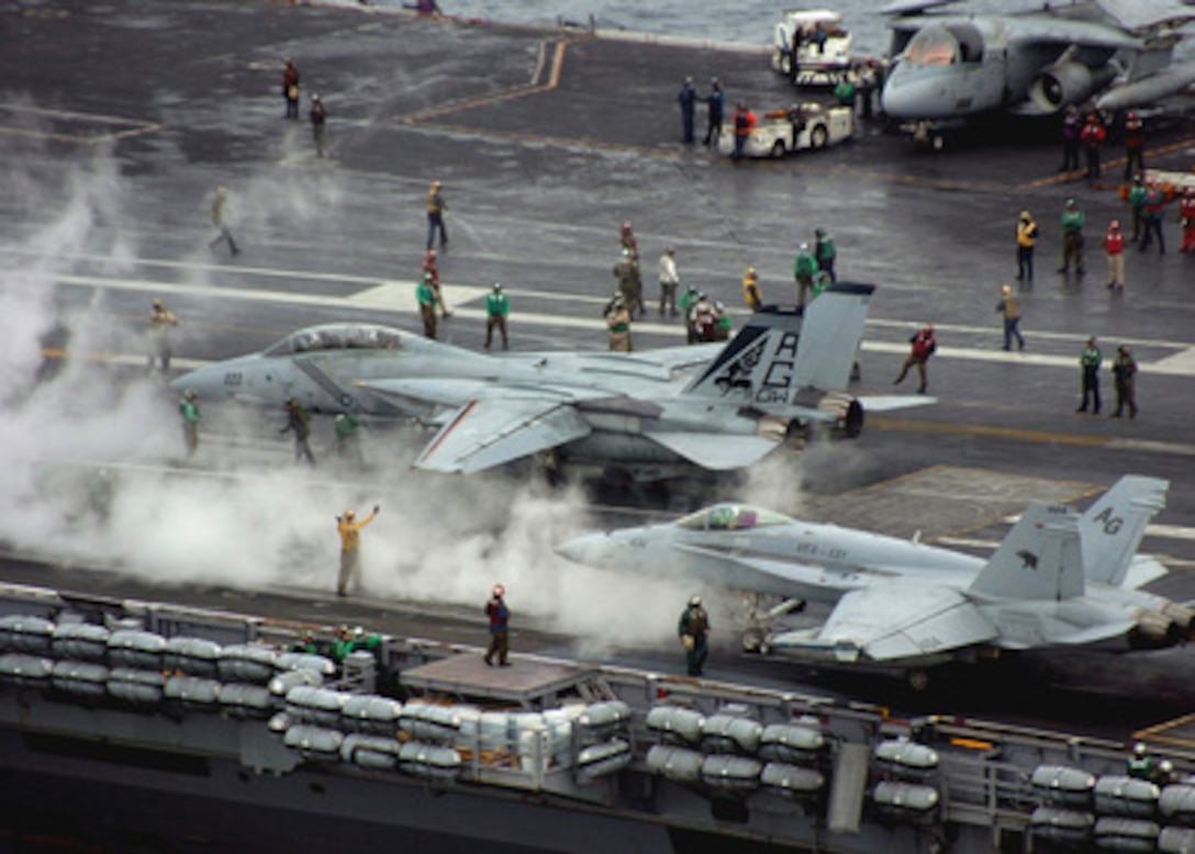 An F-14B Tomcat (left) and an F/A-18C Hornet (right) are readied for launch from the flight deck of the aircraft carrier USS George Washington (CVN 73) as it operates in the Atlantic Ocean on Oct. 20, 2004. Washington is conducting carrier strike group sustainment training off the east coast of the United States. The Tomcat is assigned to Fighter Squadron 143 and the Hornet is assigned to Fighter Attack Squadron 131. 