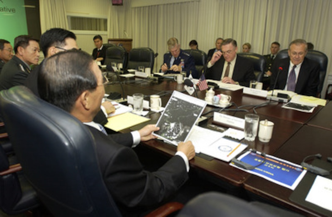 South Korean Minister of National Defense Yoon Kwang-ung looks at a satellite photo of North and South Korea given to him by Secretary of Defense Donald H. Rumsfeld during a meeting in the Pentagon on Oct 22, 2004. Rumsfeld and Yoon are meeting to discuss defense issues of mutual interest. 