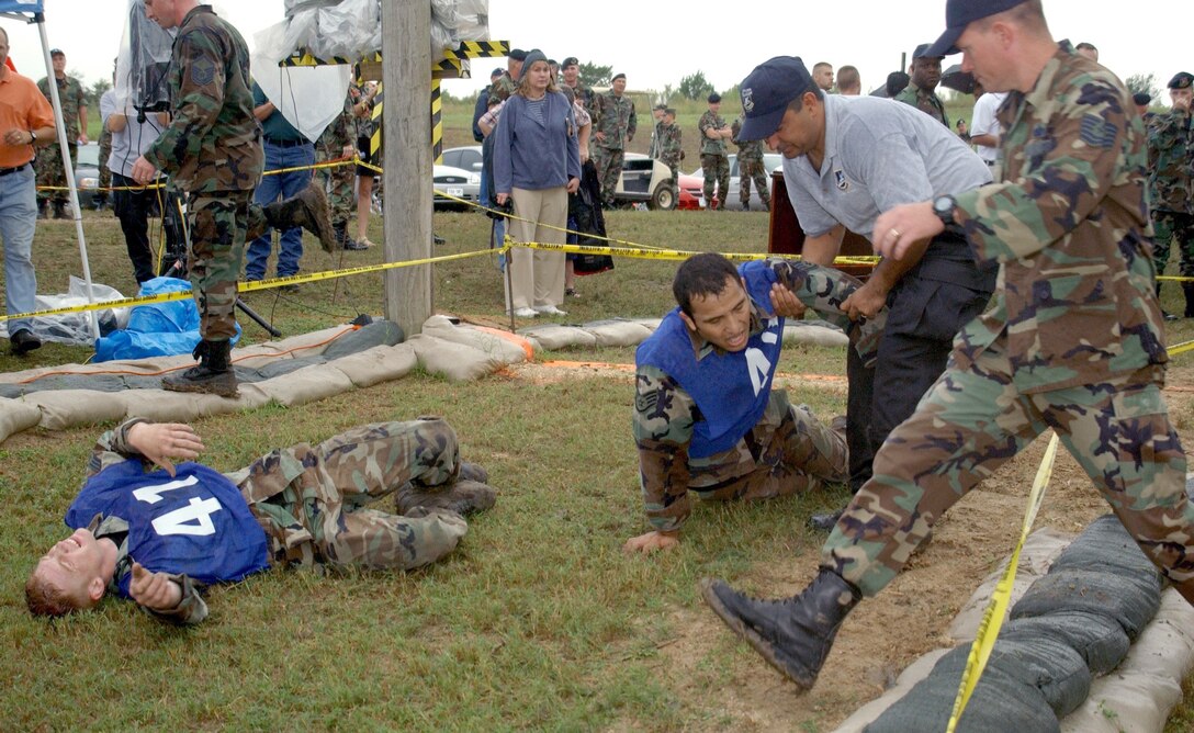 LACKLAND AIR FORCE BASE, Texas -- Senior Airman James Pittman, left, and Staff Sgt. Brandon Gonzales collapse after completing the Defender Challenge 2004 fitness challenge event.  Airman Pittman, from the 37th Security Forces Squadron here, and Sergeant Gonzales, from the 12th SFS at Randolph AFB, Texas, are on the Air Education and Training Command team.  The annual Defender Challenge here pits security forces teams from Air Force major commands, the Royal Air Force Regiment and the Department of Energy against each other in events that test marksmanship, tactics, physical fitness and teamwork.  This year's competition runs Oct. 23 to 28.  (U.S. Air Force photo by Gary Emery)