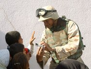 NEAR BALAD AIR BASE, Iraq -- First Lt. Yasir Archbold shows students at an elementary school here a photo he took with his digital camera Oct. 24.  The visit was part of Operation Pencil Box, a humanitarian project to deliver school supplies to Iraqi children.  Lieutenant Archbold is assigned to the 332nd Air Expeditionary Wing plans and programs office at the air base.  (U.S. Air Force photo by Staff Sgt. Ryan Hansen)
