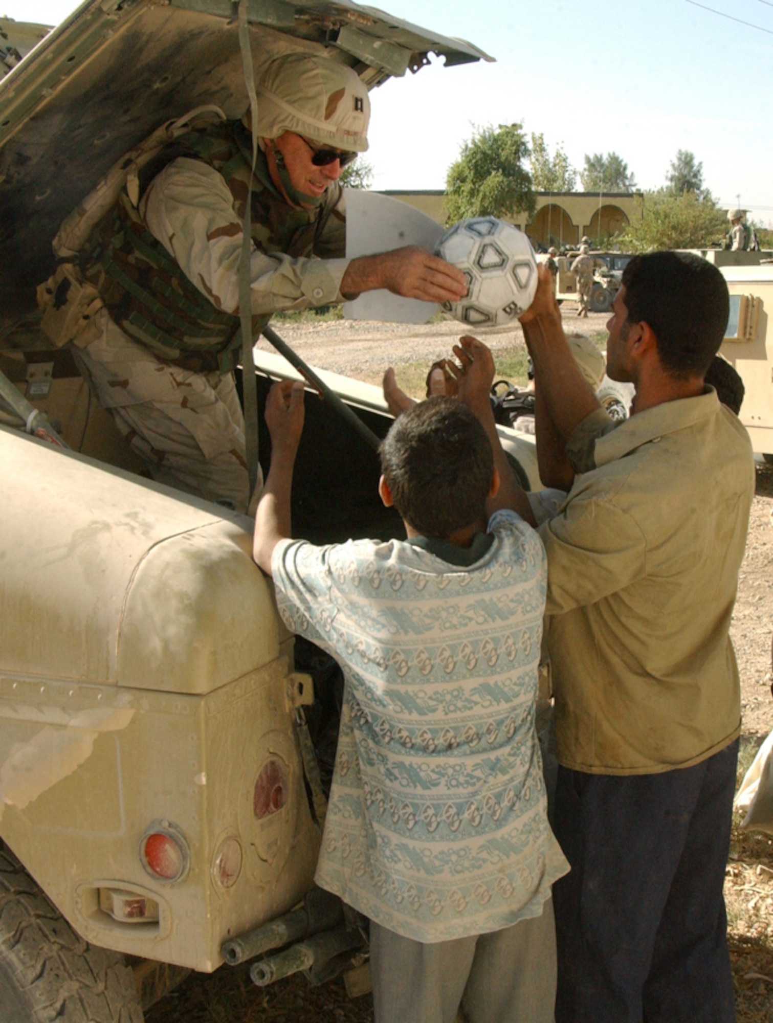 NEAR BALAD AIR BASE, Iraq -- Chaplain (Capt.) Quinton Collins gives away a soccer ball during a visit to an elementary school here Oct. 24.  The visit was part of Operation Pencil Box, a humanitarian project to deliver school supplies to Iraqi children.  Chaplain Collins is assigned to the 332nd Air Expeditionary Wing chapel at the air base.  (U.S. Air Force photo by Staff Sgt. Ryan Hansen)