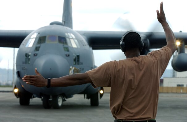 Staff Sgt. Austin Layton marshals a C-130 Hercules aircraft Oct. 24 at the international airport at Kigali, Rwanda.  He is a flight manager assigned to the 322nd Air Expeditionary Group.  Sergeant Jackson is deployed from Ramstein Air Base, Germany, supporting a humanitarian mission to help the African Union mitigate the crisis in Sudan's Darfur Region.  (U.S. Air Force photo/Staff Sgt. Tony Tolley)