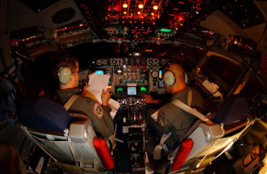 Air Force Capt. Brian Gilpatrick (left) and 1st Lt. Nils Hallberg prepare for takeoff in a KC -135R Stratotanker from Royal Air Force Station Mildenhall, England, on Oct. 20, 2004. About 30 U.S. Air Forces Europe service men and women are deploying to Kigali, Rwanda, to begin preparations for the arrival of two U.S. Air Force C-130 Hercules aircraft and about 120 airmen who will support the deployment of African Union forces to the Darfur region of Sudan. The Stratotanker is assigned to the 351st Air Refueling Squadron, 100th Air Refueling Wing, Royal Air Force Station Mildenhall, England. 