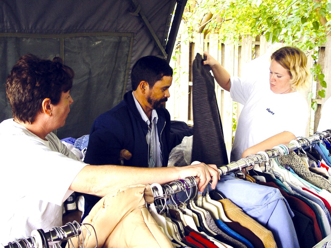 WICHITA, Kan. -- Senior Master Sgt. Denise Mikolajczyk (left) and Tech. Sgt. Freedom Bruce (right) help a homeless veteran find a warm coat during a homeless veterans stand down here Oct. 22.  Sergeant Mikolajczyk is assigned to the 22nd Mission Support Squadron;  Sergeant Bruce is assigned to the 22nd Communications Squadron.  Both Airmen are stationed at nearby McConnell Air Force Base.  (U.S. Air Force photo by Airman 1st Class Angelique Smythe)