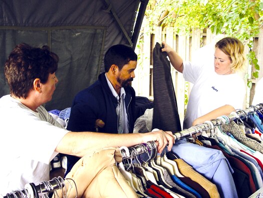 WICHITA, Kan. -- Senior Master Sgt. Denise Mikolajczyk (left) and Tech. Sgt. Freedom Bruce (right) help a homeless veteran find a warm coat during a homeless veterans stand down here Oct. 22.  Sergeant Mikolajczyk is assigned to the 22nd Mission Support Squadron;  Sergeant Bruce is assigned to the 22nd Communications Squadron.  Both Airmen are stationed at nearby McConnell Air Force Base.  (U.S. Air Force photo by Airman 1st Class Angelique Smythe)