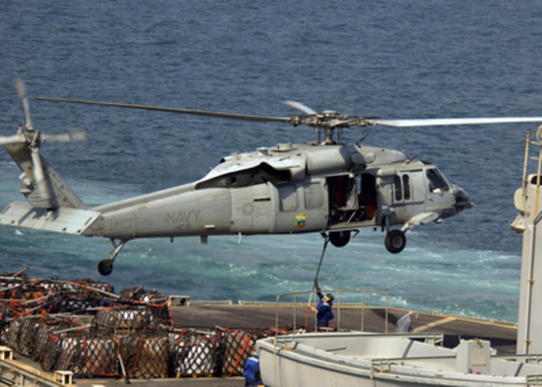 A sailor aboard the USS Seattle (AOE 3) attaches a cargo sling to the hook of an SH-60 Seahawk during vertical replenishment operations conducted with the USS Harpers Ferry (LSD 49) in the northern Persian Gulf on Sept. 22, 2004. The Seahawk is assigned to Helicopter Support Squadron 5. The Seattle and Harpers Ferry are operating in the Persian Gulf in support of Operation Iraqi Freedom. 