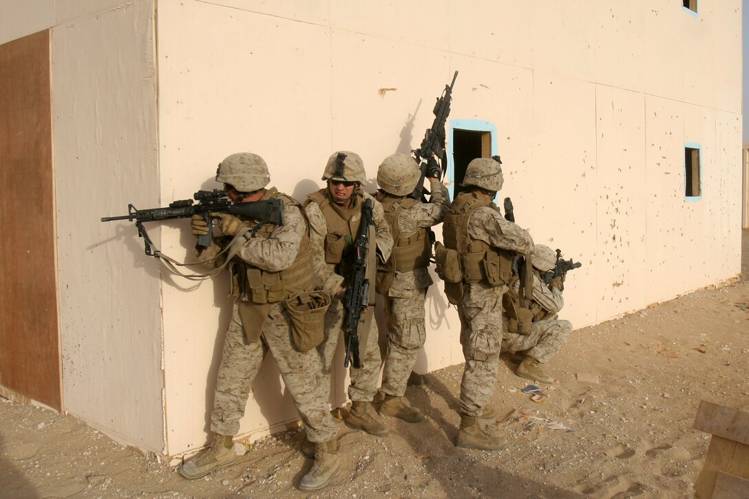 Light Armored Vehicle Scouts with Weapons Company Battalion Landing Team 2/5, 15th Marine Expeditionary Unit, take cover while waiting for a breach charge to explode during a live fire Military Operations in Urban Terrain exercise in Northern Kuwait.::r::::n:: Weapons Company came ashore to Kuwait in late June to conduct sustainment training, ensuring vital war fighting skills are not lost.::r::::n::    Kuwait provides open space for the company to practice combat driving skills and ranges to conduct live fire exercises.::r::::n::    The Camp Pendleton, Calif. based 15th MEU is comprised of approximately 2,200 Marines and Sailors and is a forward deployed force of readiness capable of conducting numerous operations, such as Non-Combatant Evacuation Operations, Humanitarian Assistance Operations and a wide range of amphibious missions. The 15th MEU is currently conducting sustainment training in Kuwait. (Official USMC photo by Cpl. Stephen Holt)(Released)::r::::n::