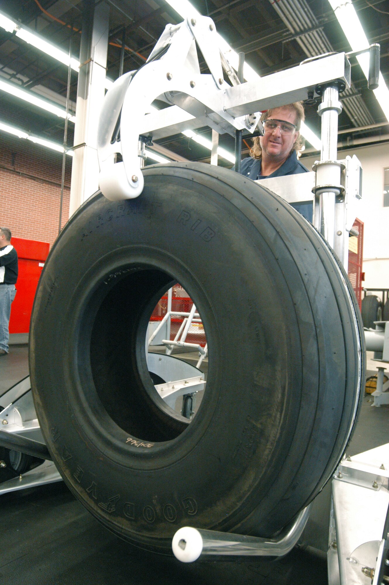 ROBINS AIR FORCE BASE, Ga. -- Darren Rew uses the Ergo Control 300 Robot, a wheel and tire handling vehicle, to move a C-5 Galaxy tire to the work area.  Workers used to have to lift the 250-pound tires by hand.  Mr. Rew is an aircraft mechanic in the maintenance directorate's C-5 wheel and tire shop here.  (U.S. Air Force photo by Sue Sapp)