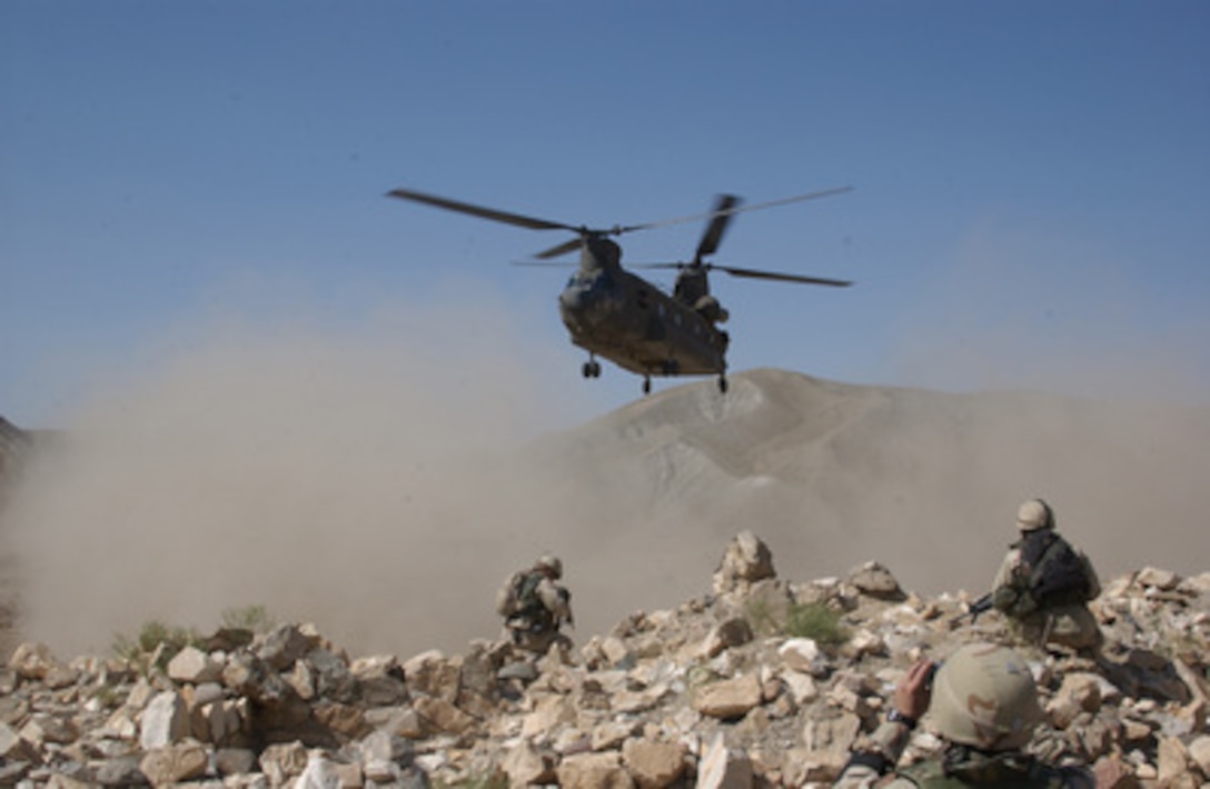 Clouds of dust are kicked up by the rotor wash of a CH-47 Chinook helicopter as it comes in for a landing to pick up security forces during a Humanitarian Aid mission in Afghanistan on Sept. 6, 2004. Family members of the soldiers of Task Force Pirate donated shoes, clothes and food, which were distributed to residents of a village called Jegdalek in Afghanistan. 