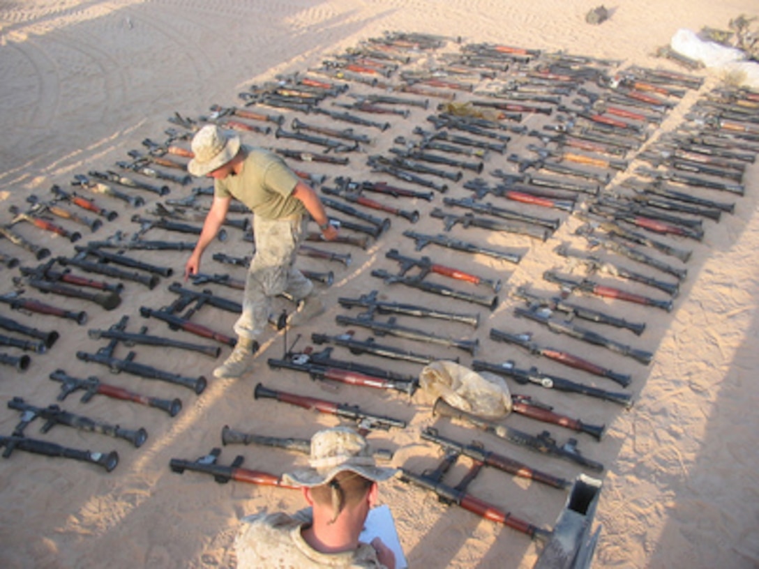 U.S. Marines inventory a large quantity of weapons stockpiled by the Muqtada Militia in An Najaf, Iraq, on Sept. 3, 2004. Marines from the 11th Marine Expeditionary Unit Explosive Ordnance Disposal teams recovered the cache of weapons. 
