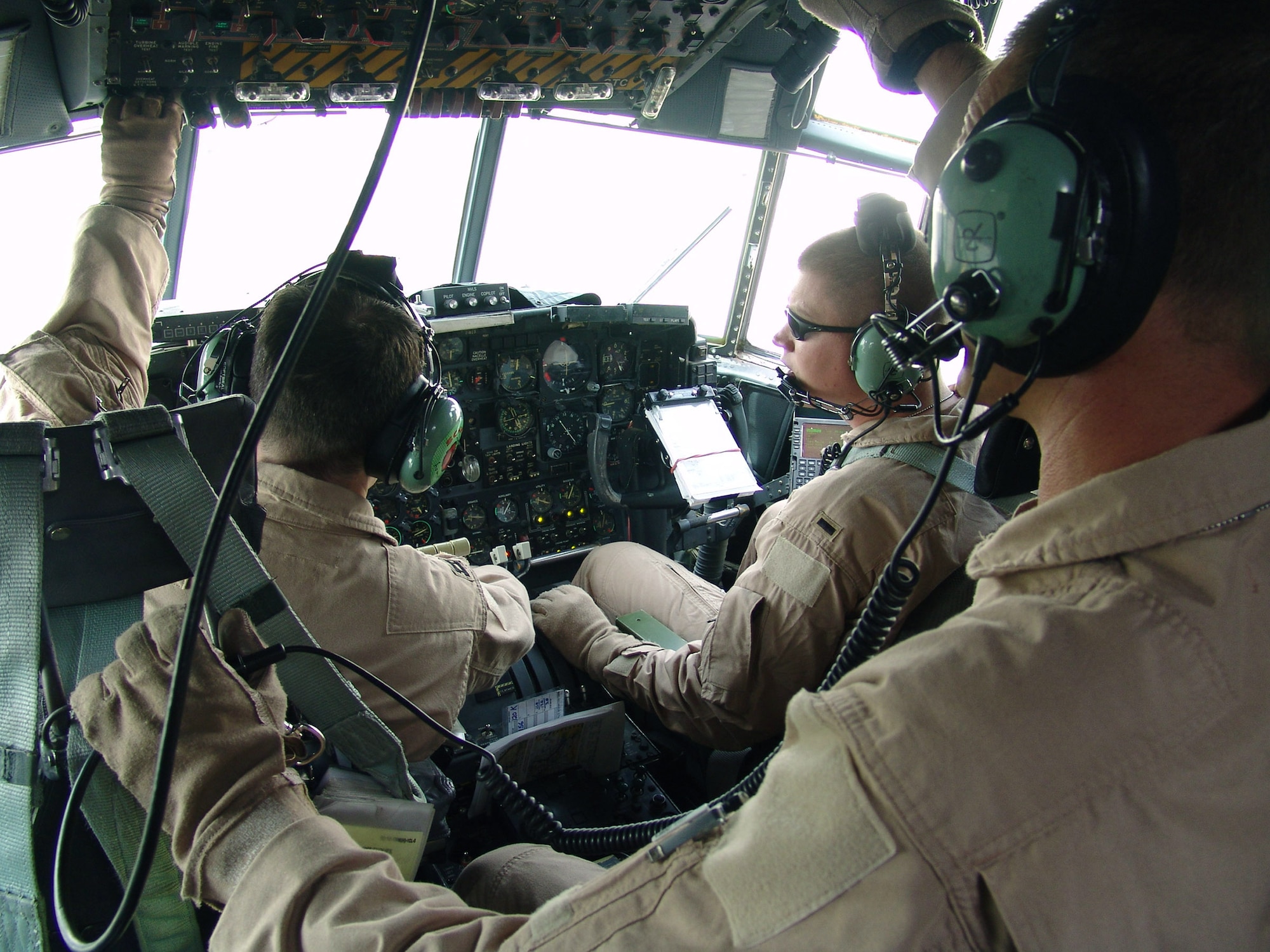 SOUTHWEST ASIA -- (Clockwise from left) C-130 Hercules pilot Capt. Todd Linton and his co-pilot 1st Lt. Robert Cureton and flight engineer Master Sgt. Gary Corley run through checklists after taking off from a forward-deployed location here Sept. 14.  The crew is assigned to the 746th Expeditionary Airlift Squadron and deployed from Ramstein Air Base, Germany.  (U.S. Air Force photo by Capt. Denise Boyd) 