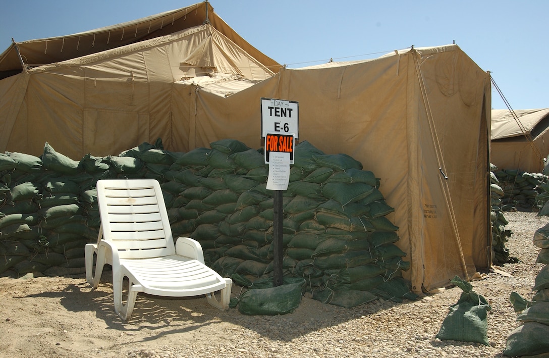 BALAD AIR BASE, Iraq -- In an attempt at a little humor a "for sale" sign is posted in front of a tent along with a list of amenities here Sept. 13.  The list reads: A/C included, corner lot, desert view, gated community, sleeps eight, fitness facilities close by, no pets allowed, and 24 hour security system.  To improve the quality of life living standards, many Airmen have been moved out of the tents and into trailers.  Eventually all Airmen will be moved out of the tents.  (U.S. Air Force photo by Airman 1st Class Joshua T Jasper) 