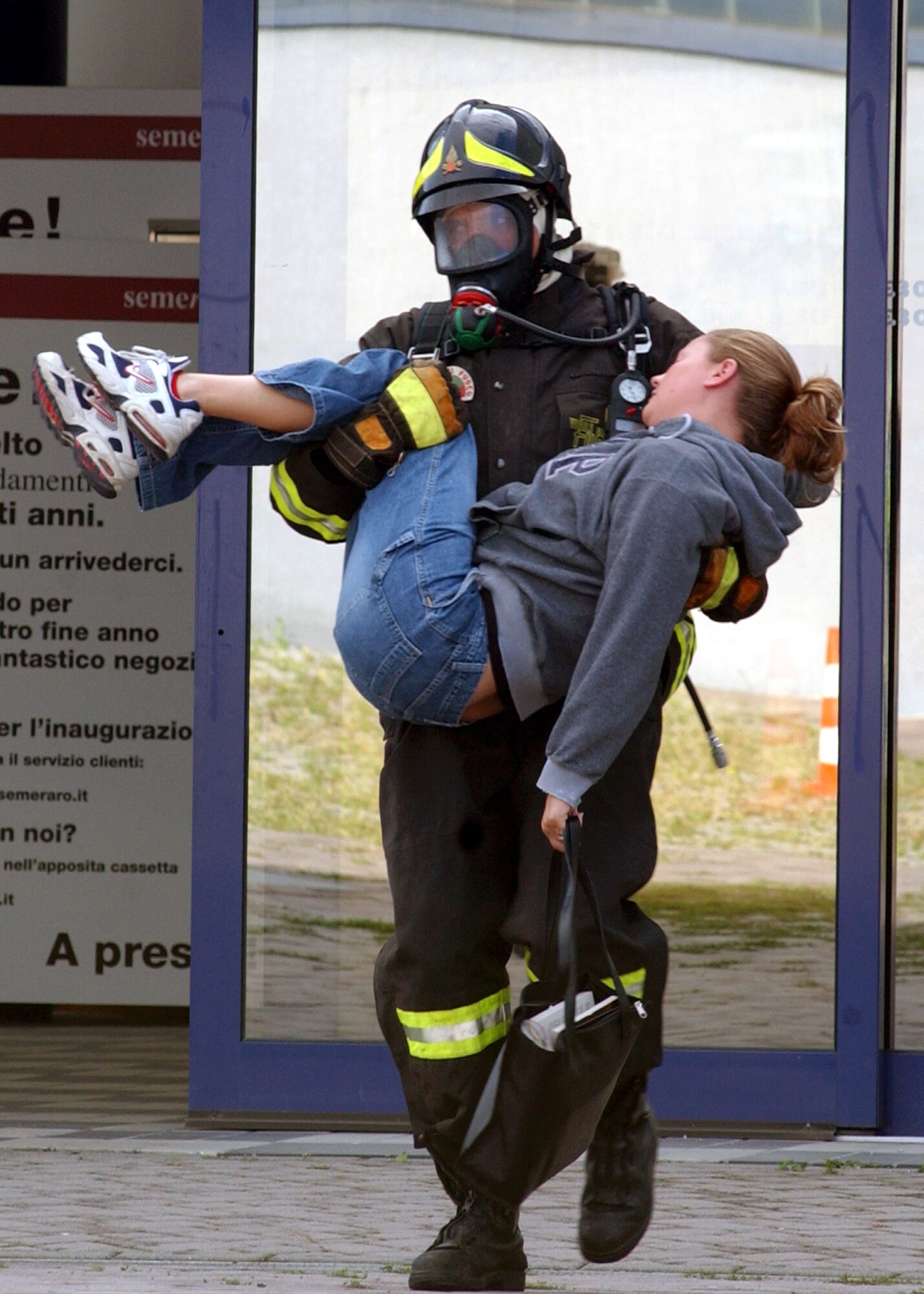 ROVEREDO IN PIANO, Italy -- An Italian firefighter rescues Staff Sgt. Bobbi Gilbert from a local store after she simulates being overcome by toxic fumes during a mass casualty exercise here Sept. 13.  The exercise involved Airmen from nearby Aviano Air Base and Italian authorities, and allowed them to practice and strengthen their emergency response skills together.  Sergeant Gilbert is assigned to the base's 603rd Air Control Squadron.  (U.S. Air Force photo by Senior Airman Nichole Adamowicz)