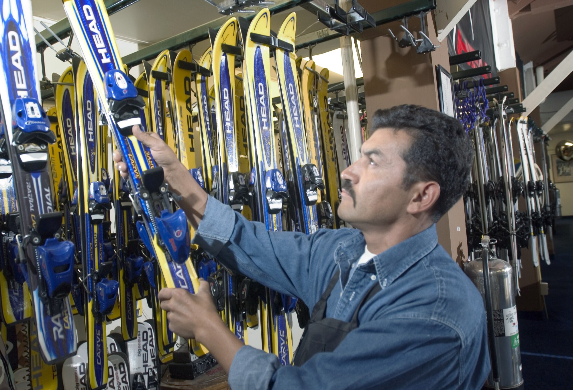 MOUNTAIN HOME AIR FORCE BASE, Idaho -- Raul Hernandez hangs a pair of children's skis on a storage rack next to dozens of others at the base outdoor recreation supply office here.  He cares for all the winter equipment.  (U.S. Air Force photo by Master Sgt. Lance Cheung)
