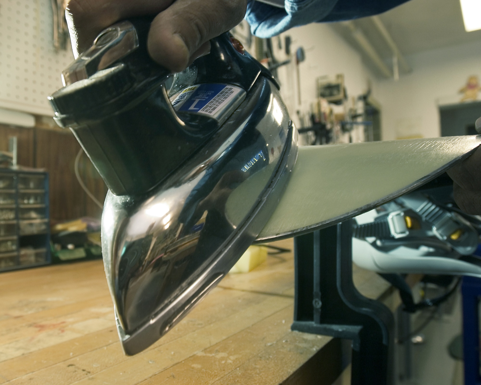 MOUNTAIN HOME AIR FORCE BASE, Idaho -- Raul Hernandez uses an iron to apply wax to the bottom of snowboards and skis.  He cares for more than 600 pairs of skis, 100 snowboards and countless cross-country skis, snowshoes and sleds.  (U.S. Air Force photo by Master Sgt. Lance Cheung)