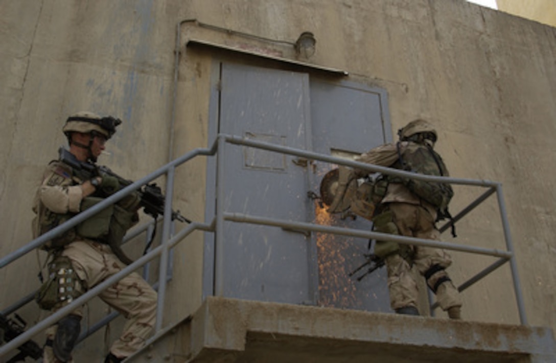 A soldier from the 2nd Infantry Division Stryker Brigade Combat Team uses a power saw to cut the lock off a door at the granary in Tall Afar, Iraq, on Sept. 9, 2004. Charlie Company of the 5th Battalion is attempting to rid the town of a build up of insurgents in support of Operation Iraqi Freedom. 