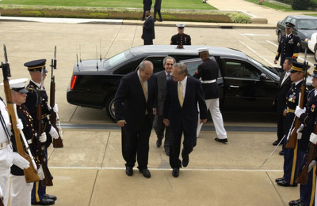 Secretary Rumsfeld escorts Iraqi Prime Minister Ayad Allawi into the ...