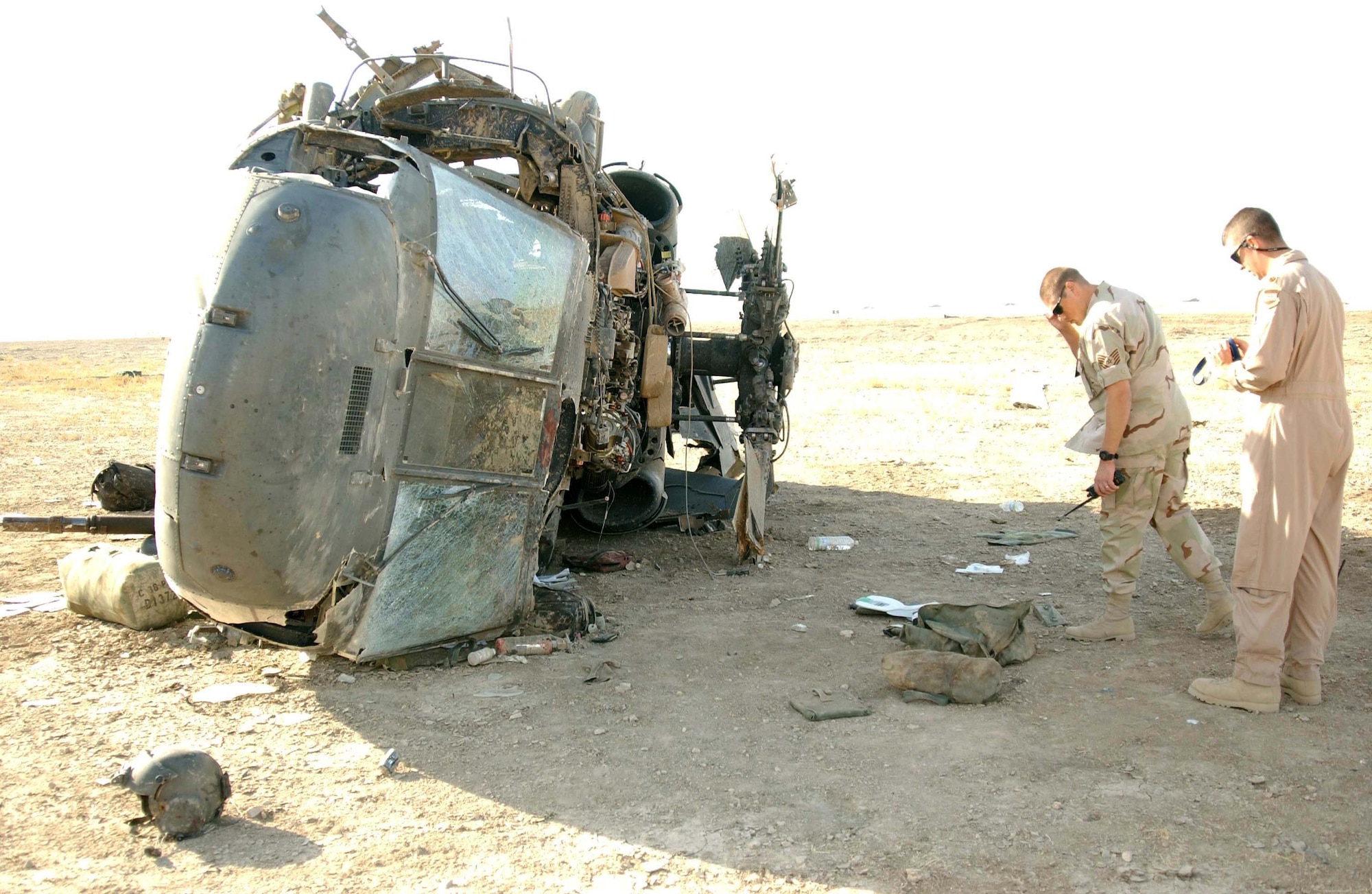 TALLIL AIR BASE, Iraq -- Local safety officials inspect the wreckage of a Sept. 21 Army UH-60 Blackhawk crash here.  All four Soldiers on board were rescued from the helicopter by people of the 407th Air Expeditionary Group and 407th Expeditionary Medical Squadron.  (U.S. Air Force photo by Airman 1st Class Jeff Andrejcik)
