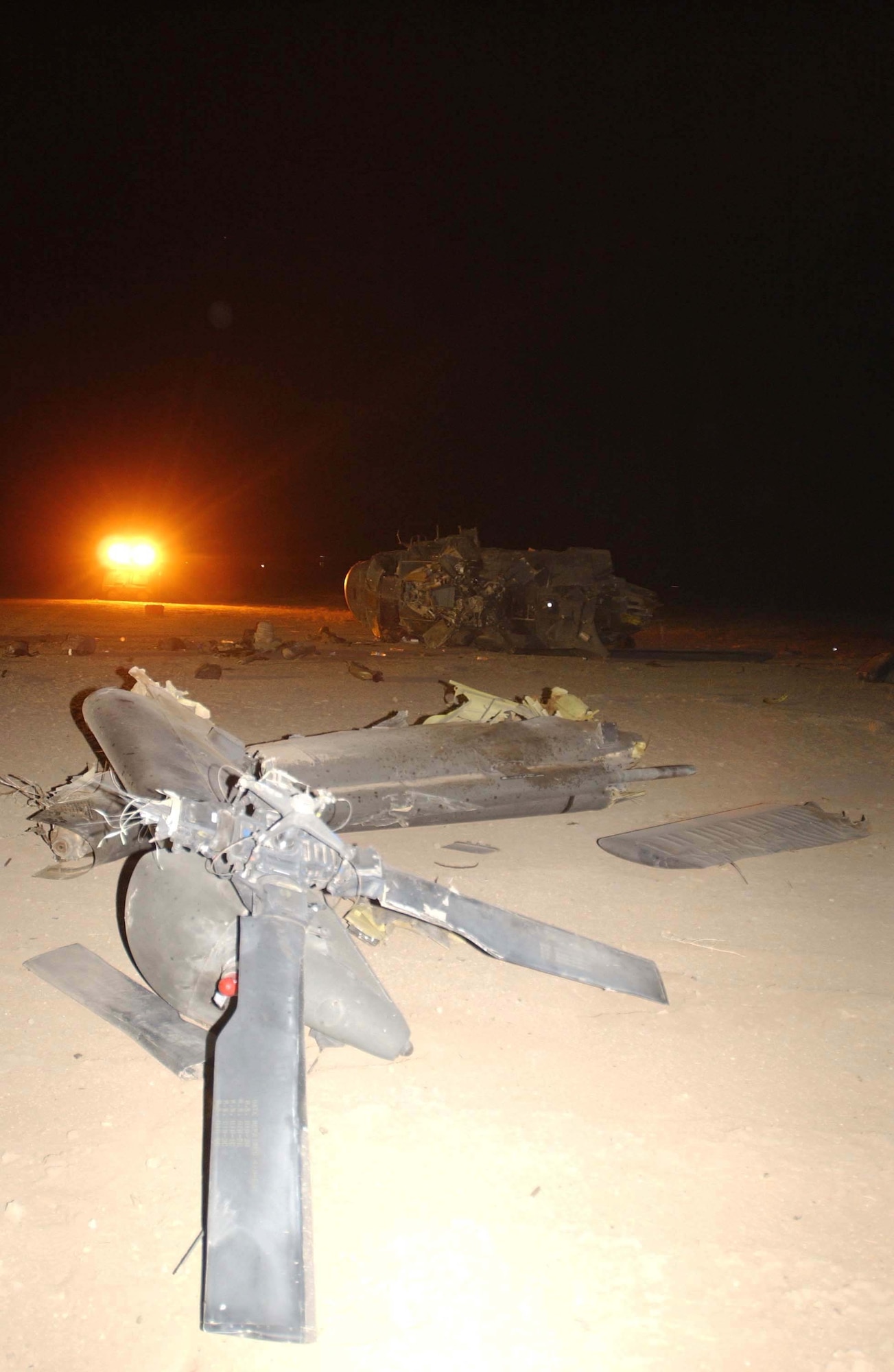 TALLIL AIR BASE, Iraq -- Lights from a portable lighting cart illuminate the wreckage of an Army UH-60 Blackhawk crash across the flightline here Sept. 21.  All four Soldiers on board were rescued from the helicopter by people of the 407th Air Expeditionary Group and 407th Expeditionary Medical Squadron.  (U.S. Air Force photo by Staff Sgt. Craig Clapper)