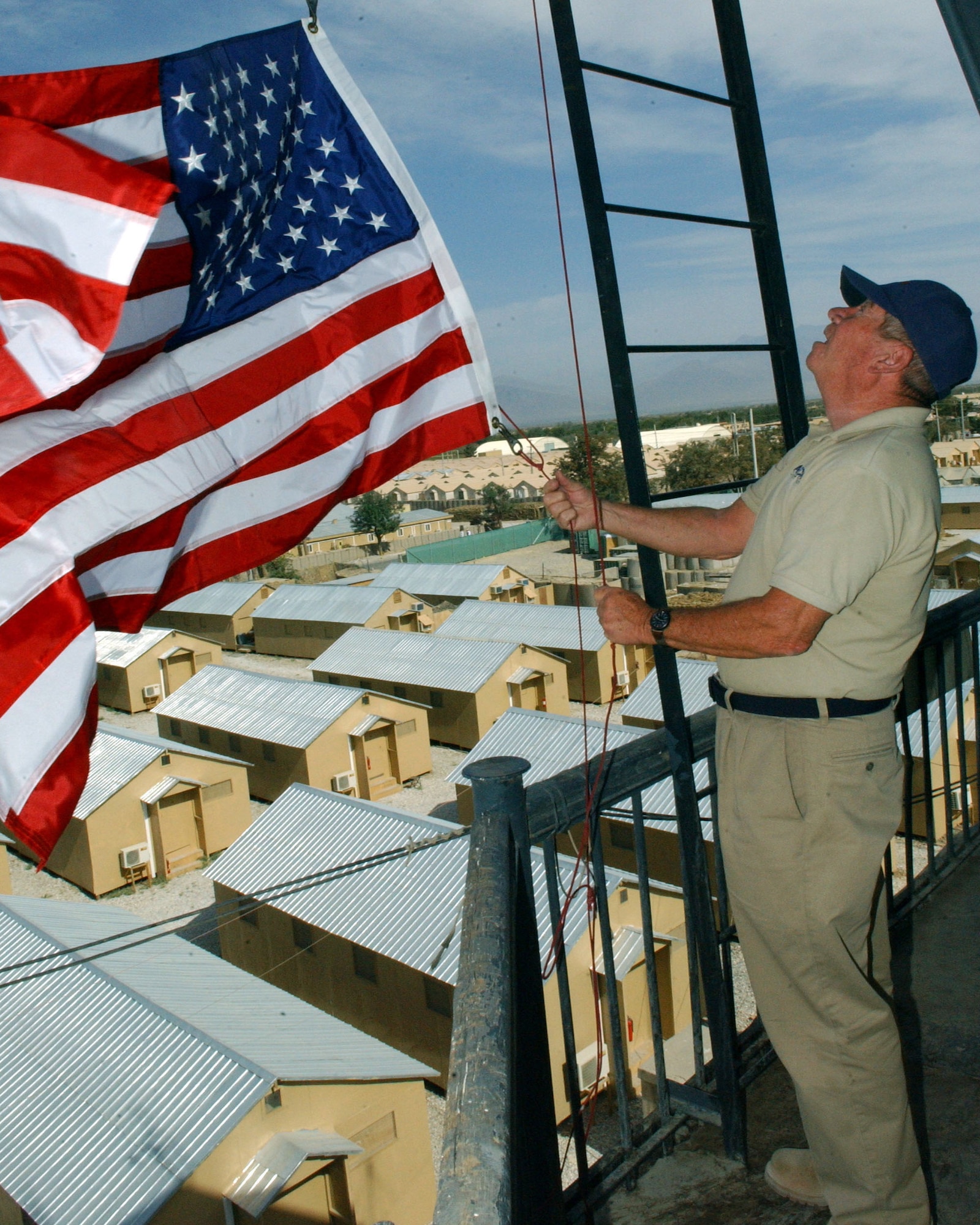 BAGRAM AIR BASE, Afghanistan -- Barry McKelvy prepares to fly a U.S. flag for a contributor of the 455th Air Expeditionary Wing's flag-flying program.  The program coordinator flies flags here in honor of family and friends. Their donations are used to provide supplies for local orphans.  Mr. McKelvy is an airfield manager here.  (U.S. Air Force photo by Staff Sgt. Jennifer Lindsey)