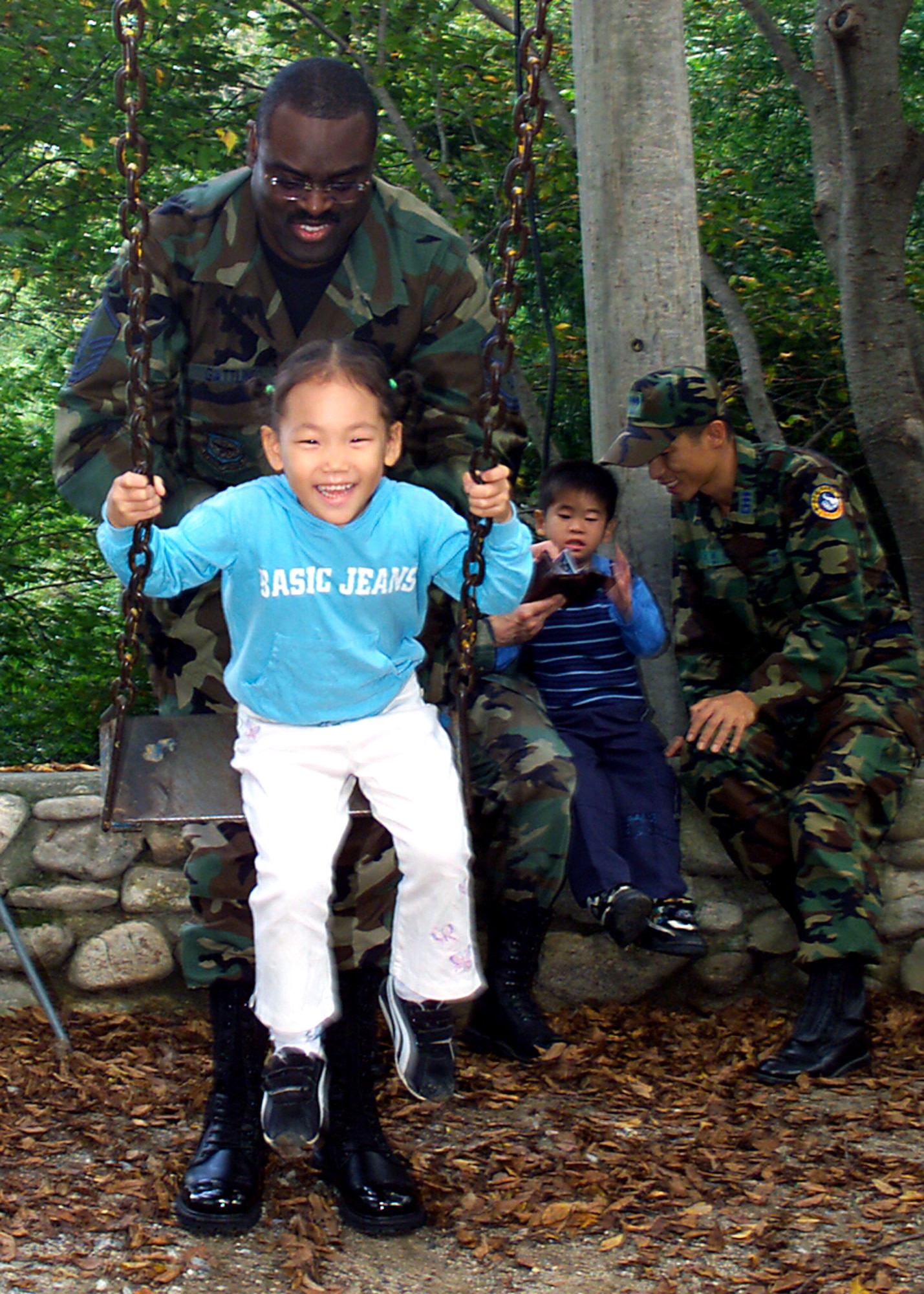 GWANGJU, South Korea -- Master Sgt. Frederick Gattling and a South Korean airman play with children at a local orphanage Sept. 24.  Sergeant Gattling is a chaplain assistant with the 3rd Air Expeditionary Group.  (U.S. Air Force photo by Staff Sgt. James Arrowood)