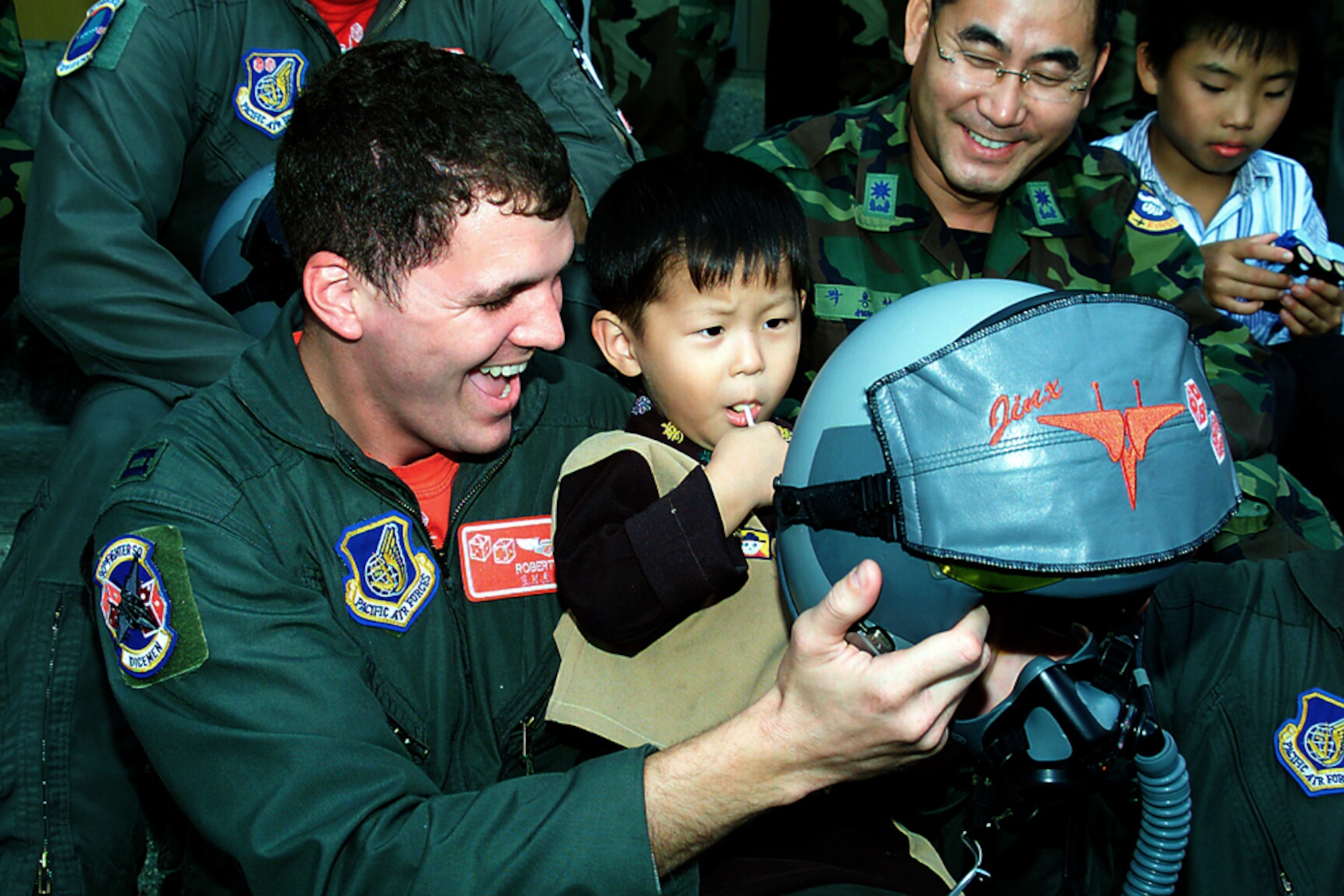 GWANGJU, South Korea -- Capt. Robert Lee shows a helmet to a child during a visit to a local orphanage Sept. 24.  Captain Lee is a 3rd Air Expeditionary Fighter Squadron F-15E Strike Eagle pilot.  (U.S. Air Force photo by Staff Sgt. James Arrowood)