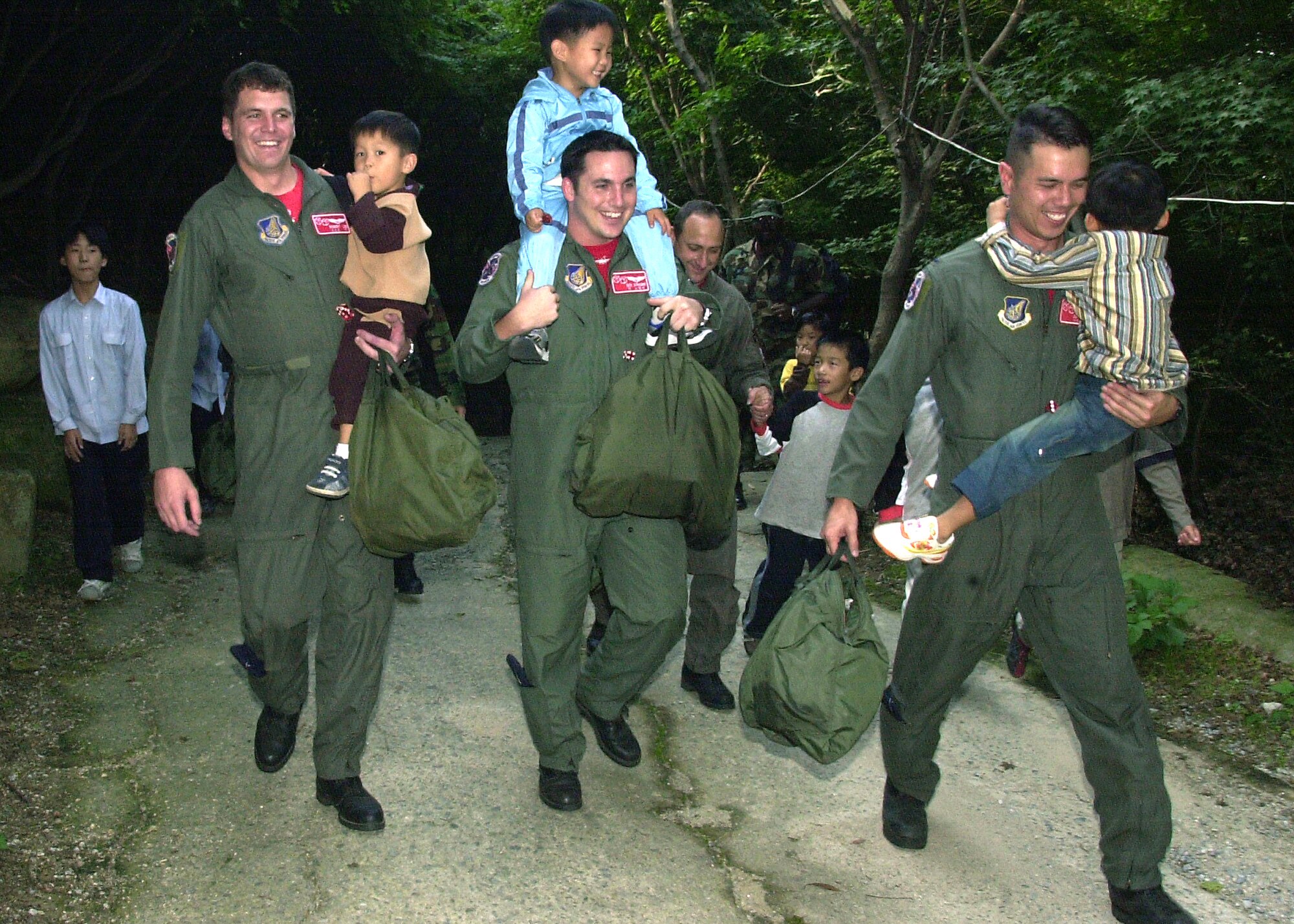 GWANGJU, South Korea -- (Left to right) Capt. Robert Lee and 1st Lts. Richard Stringer and Josh Cummings carry children during a visit to a local orphanage Sept. 24.  Captain Lee and Lieutenant Stringer are 3rd Air Expeditionary Fighter Squadron F-15E Strike Eagle pilots, and Lieutenant Cummings is a 3rd AEFS weapons system officer.  (U.S. Air Force photo by Staff Sgt. Adam R. Wooten)     