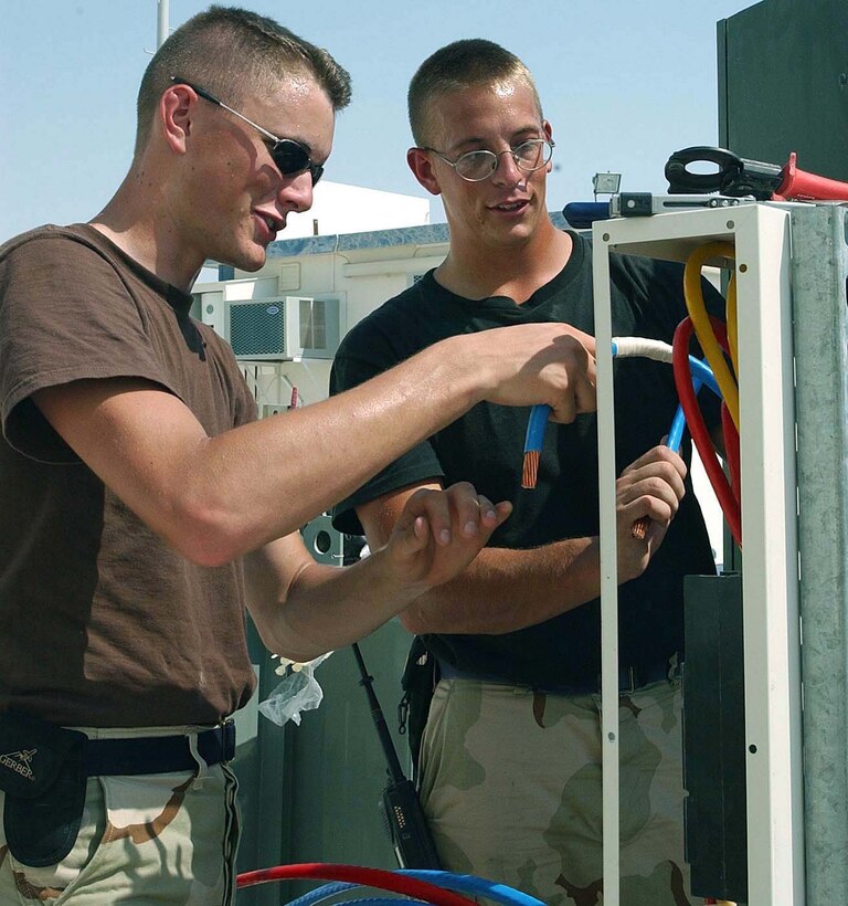 AL UDEID AIR BASE, Qatar -- Airman 1st Class Thomas Quinton (left) and Senior Airman Nick Nenichka install a new breaker to ensure maximum power efficiency at the Combined Air Operations Center here.  Both Airmen are assigned to the 379th Air Expeditionary Wing's civil engineer squadron.  Airman Quinton is deployed from Seymour Johnson Air Force Base, N.C., and Airman Nenichka is from Robins Air Force Base, Ga.  (U.S. Air Force photo by 1st Lt. Jamie Humphries)