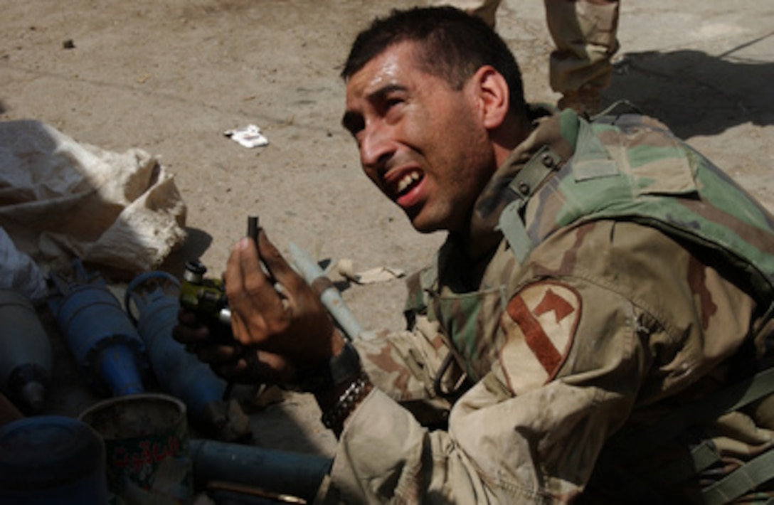 U.S. Army Lt. Shane Aguero holds up some material used in making an improvised explosive device that was found along with a weapons cache stockpiled by the Muqtada Militia in the Al Thawra district of Baghdad, Iraq, on Sept. 5, 2004. Aguero is a platoon leader in the 1st Brigade Combat Team, 1st Calvary Division. 