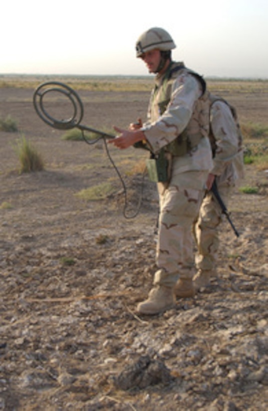 Army Spc. Sean Hogan uses a mine detector to search for improvised explosive devices near Baqubah, Iraq, on Sept. 24, 2004. The 141st Engineer Battalion, known as the "Trailblazers," is performing sweeps in the Baqubah area. The 141st is attached to 3rd Brigade Combat Team, 1st Infantry Division. 