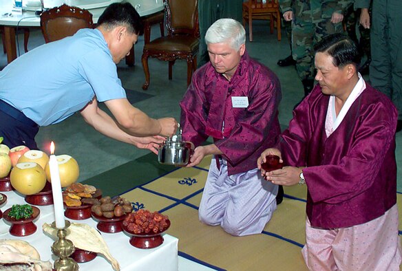 GWANGJU AIR BASE, South Korea -- Col. Dave Watson (center) and South Korean air force Brig. Gen. Young Woo Kwon participate in a traditional ceremony honoring ancestors from the past, during a Chu Sok holiday celebration here Sept. 28.  They are dressed in traditional South Korean clothing worn during holidays.  Colonel Watson is the 3rd Air Expeditionary Group commander, and General Kwon is the 1st Fighter Wing commander.  (U.S. Air Force photo by Staff Sgt. James Arrowood)