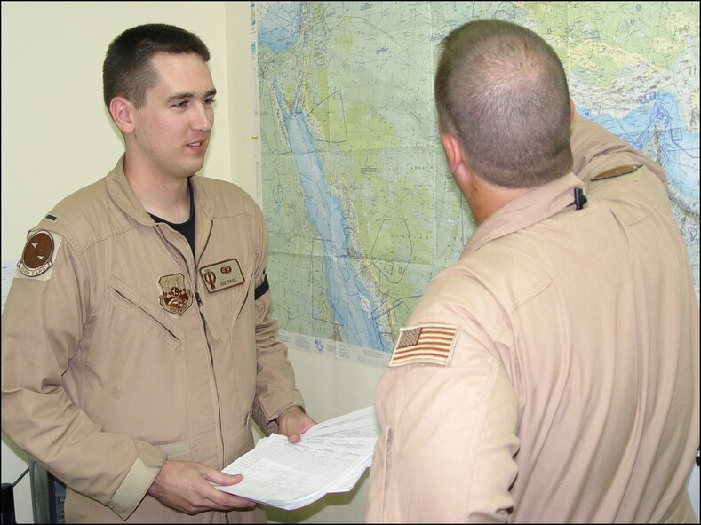 SOUTHWEST ASIA -- First Lt. Joe Page discusses a flight plan with Master Sgt. Troy Doane at a forward-deployed location.  Lieutenant Page is a flight planner with the 908th Expeditionary Air Refueling Squadron, and Sergeant Doane is the chief boom operator for the squadron.  The lieutenant is deployed from Minot Air Force Base, N.D., where he is a missile combat crew commander.  (U.S. Air Force photo by Tech. Sgt. Gino Mattorano)
