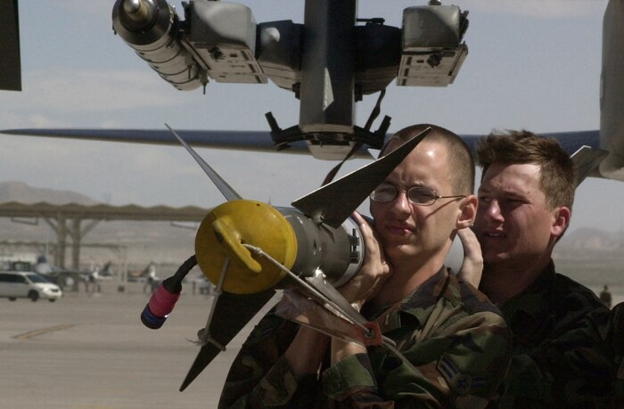 NELLIS AIR FORCE BASE, Nev. -- Airman 1st Class Mathew Quinn (front) and Senior Airman Lucas Long prepare to load a missile onto an F-15 Eagle here March 28.  About 10,000 U.S. and coalition forces are participating in the exercise, which runs through April 2.  The Airmen are weapons loaders from the 46th Aircraft Maintenance Squadron at Eglin Air Force Base, Fla.  (U.S. Air Force photo by Tech. Sgt. Bob Sommer)