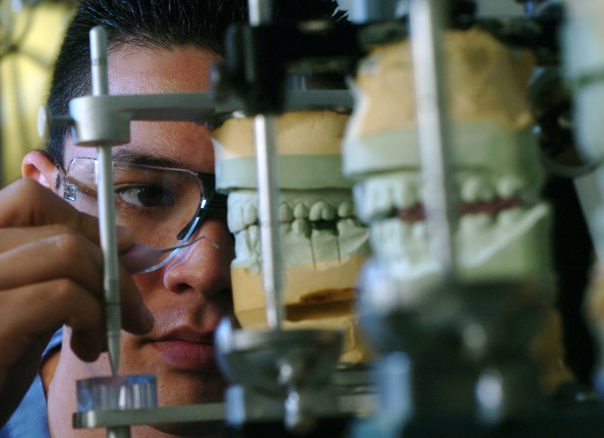 YOKOTA AIR BASE, Japan -- Airman First Class Eric Parks inspects inspects the line angle of a casts of teeth at the clinic here March 31. He is a dental laboratory technician with the 374th Dental Squadron. (U.S. Air Force photo by Master Sgt. Val Gempis)