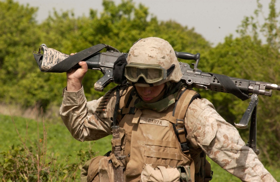 BAGHDAD, Iraq -- (April 2, 2005) - PFC Erik Garza, 22, a machine gunner with Charlie Co., Battalion Landing Team 1/1 slings his M240G machine gun over his shoulder on a patrol near the Tigris River.  The 15th Marine Expeditionary Unit (Special Operations Capable) is currently conducting security and stability operations here in the greater Baghdad area. (Official USA Photo by Sgt. Thomas Benoit)