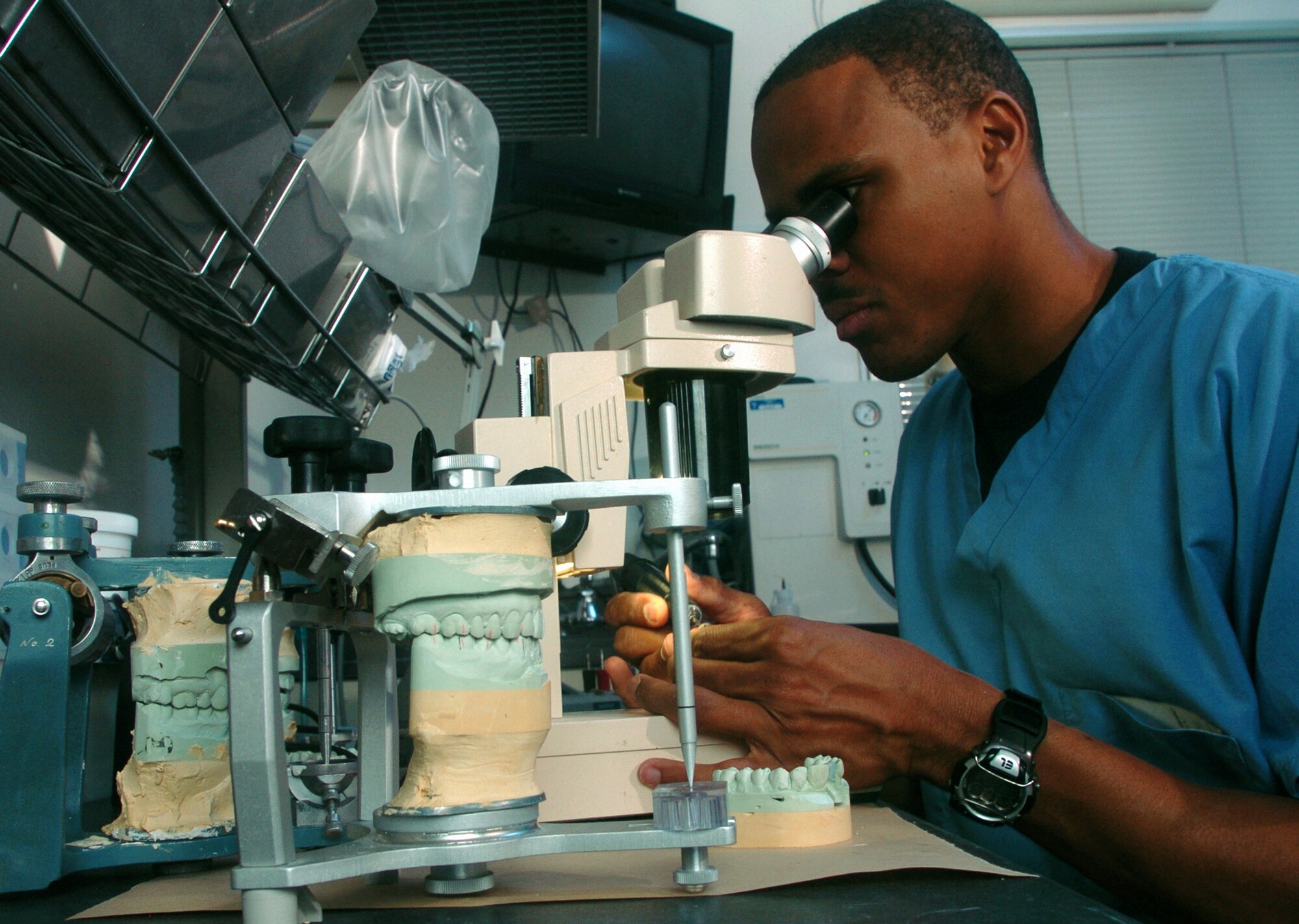 YOKOTA AIR BASE, Japan -- Tech. Sgt. Keith Kinmon uses a microscope to look for imperfections on a crown at his clinic here.  He is a dental laboratory technician assigned to the 374th Dental Squadron here.  The Airmen ensure maximum wartime readiness of Pacific Command people by providing comprehensive dental care for the active-duty servicemembers and other eligible beneficiaries.  (U.S. Air Force photo by Master Sgt. Val Gempis)