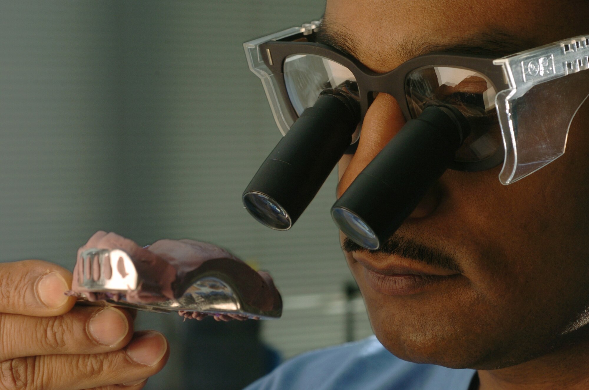 YOKOTA AIR BASE, Japan -- Maj. Andre Henriques uses orascoptic glasses to examine an impression tray.  He is a prosthodontist assigned to the 374th Dental Squadron here.  The squadron's Airmen ensure maximum wartime readiness of Pacific Command people by providing comprehensive dental care for the active-duty servicemembers and other eligible beneficiaries.  (U.S. Air Force photo by Master Sgt. Val Gempis)