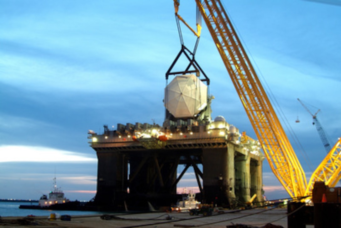 A 4-million pound radar assembly is lowered into place aboard a converted offshore oil rig at the Kiewit Offshore Services in Corpus Christi, Texas, on April 3, 2005, for what will become the Sea-Based X-band Radar for the Missile Defense Agency. The Sea-Based X-band Radar is a unique combination of an advanced-radar with a mobile, ocean-going, semi- submersible platform that will provide the nation with highly advanced ballistic missile detection with the capability to discriminate hostile missile warheads from decoys or countermeasures. The radar's mobility gives it the capability to be positioned on the ocean to support Missile Defense Agency tests and also operationally support defense of our homeland, deployed forces and allies and friends. The 282-foot high structure will be home ported in Adak, Alaska, later this year. 