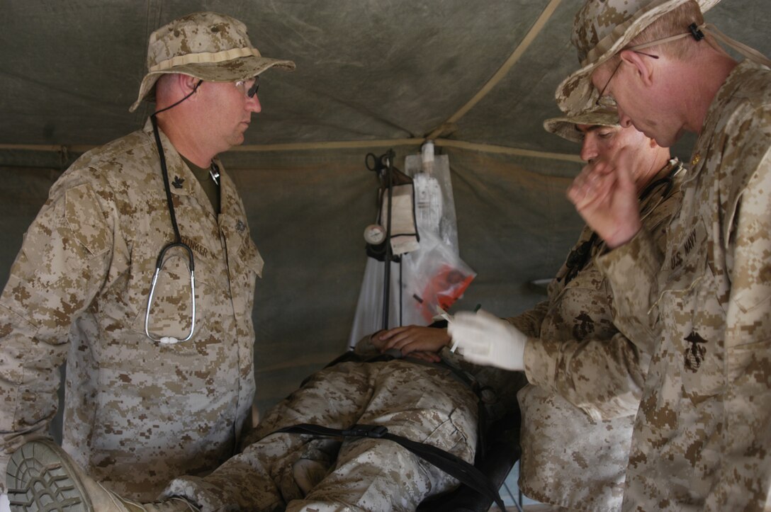 Commanders Craig Duncan and John Murray consult as to what further care the patient needs.