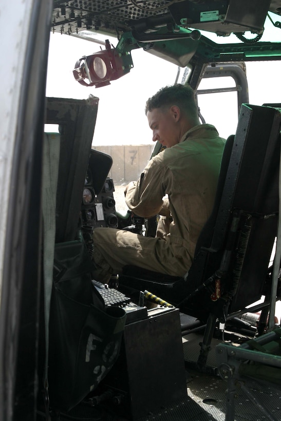 Lance Cpl. Damian M. Root, a crew chief for a UH-1N Huey from HMM-165 (REIN), 15th Marine Expeditionary Unit (Special Operations Capable), and native of Brunswick, Ga., conducts a cockpit check during some routine maintenance. The 15th MEU (SOC) is wrapping up one month of security and stabilization operations in the Greater Baghdad area