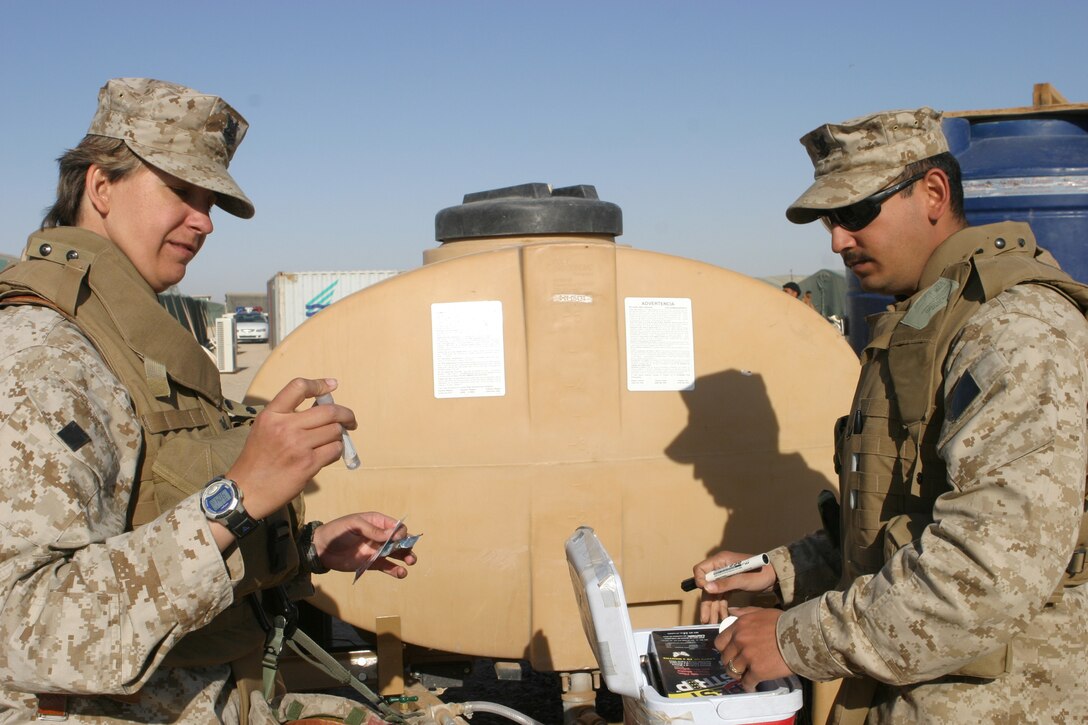 CAMP FALLUJAH, Iraq -- Petty Officer 3rd Class Firdous Halwany and Petty Officer 2nd Class Nicole Dubeck, both medical corpsmen with Combat Logistics Battalion 8, 2d Force Service Support Group (Forward), test the water quality of a water tank located at the East Fallujah Iraqi Camp. Dubeck, a native of Jacksonville, Fla., and Halwany, who hails from Atlanta, are preventative medicine technicians.