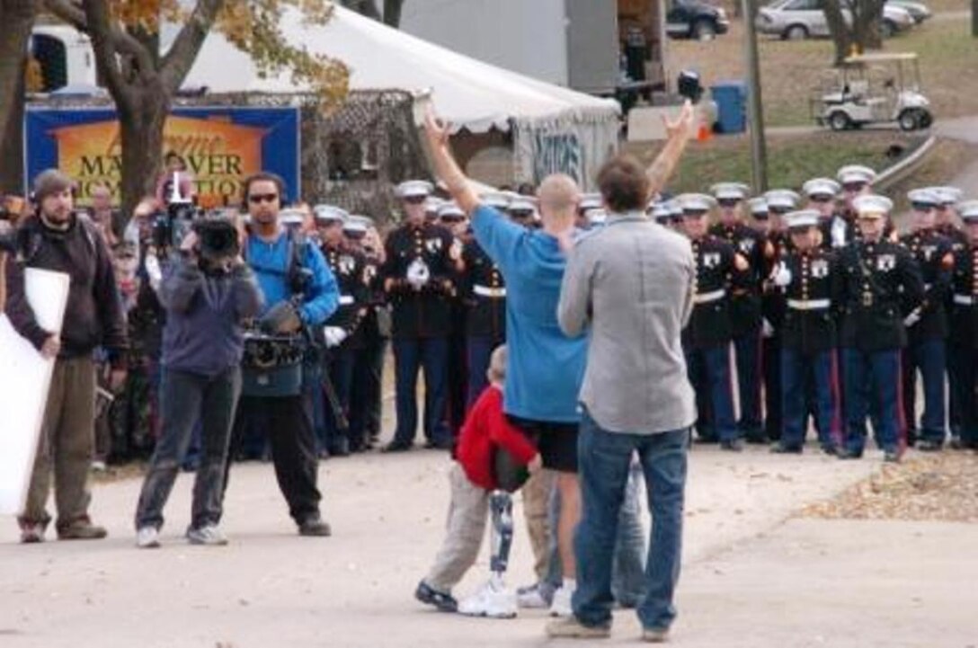 Staff Sgt. Daniel Gilyeat gives a platoon of 32 Marines an appreciative "ooh rah" for their salute at his Leavenworth, Kan., home Nov. 10. The platoon served as part of a filmed ceremony for Gilyeat's feature on the hit show "Extreme Makeover: Home Edition," where his home was remodeled free of charge. The platoon was a mere fraction of the community there to honor Gilyeat.
