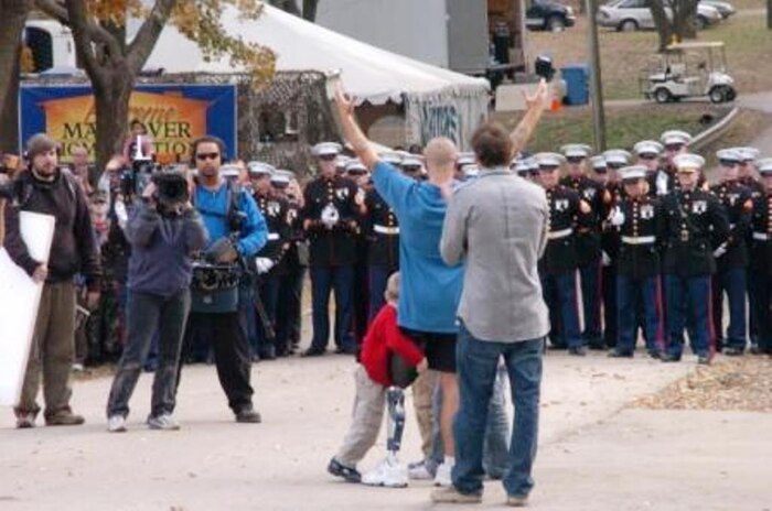 Staff Sgt. Daniel Gilyeat gives a platoon of 32 Marines an appreciative "ooh rah" for their salute at his Leavenworth, Kan., home Nov. 10. The platoon served as part of a filmed ceremony for Gilyeat's feature on the hit show "Extreme Makeover: Home Edition," where his home was remodeled free of charge. The platoon was a mere fraction of the community there to honor Gilyeat.
