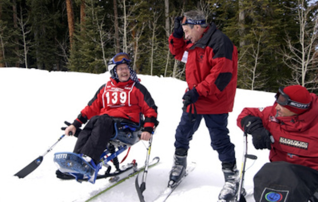Deputy Secretary of Defense Paul Wolfowitz (center) laughs with Marine Corps veteran Landon Henderson (left) and his instructor Matt Feeney, at the 19th National Disabled Veterans Winter Sports Clinic at Snowmass Village, Colo. on April 4, 2005. The clinic, organized by the Department of Veteran's Affairs and Disabled American Veterans, is the largest annual disabled, snow ski clinic in the world. 